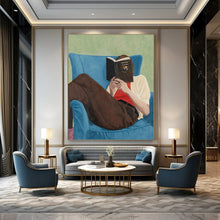 Load image into Gallery viewer, “Bookish Retreat” ,Soft green background, blue armchair, brown pants, white and red clothing, with a figure reading a book. DTP303